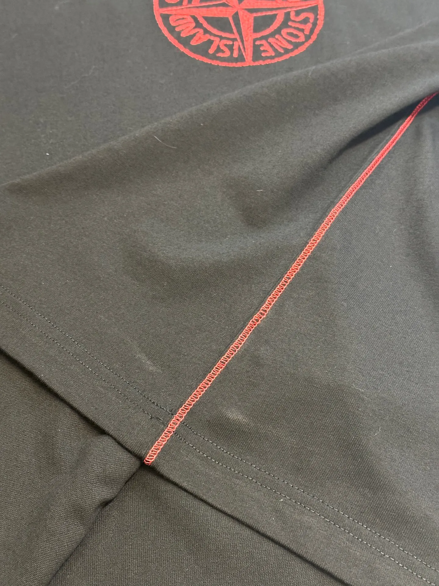🅿️270 Stonelsland Badge Embroidered Short Sleeves Customized elegant black silk cotton and linen plain fabric, with iconic red Compass badge embroidery on the chest, stitching art, and the beauty of contrasting colors. The red stitches jump on the black base. The collision of fashion and creativity exudes irresistible charm. Imported machine embroidery technology is used, and advanced computer control systems and precision mechanical components are used to realize the red Compass badge embroidery operation. Special machine for reverse topstitching and fine sewing process. Special machine is used for topstitch sewing. It requires careful preparation of the reverse side of the garment before sewing to ensure that the sewing lines are straight, the stitches are even, and the edges are smooth and beautiful.  size：s m l xl
